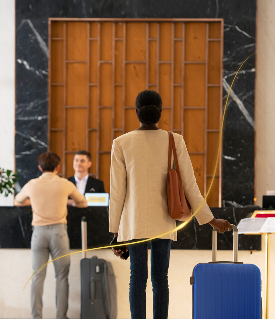mujer en el loby de un hotel con maleta azul